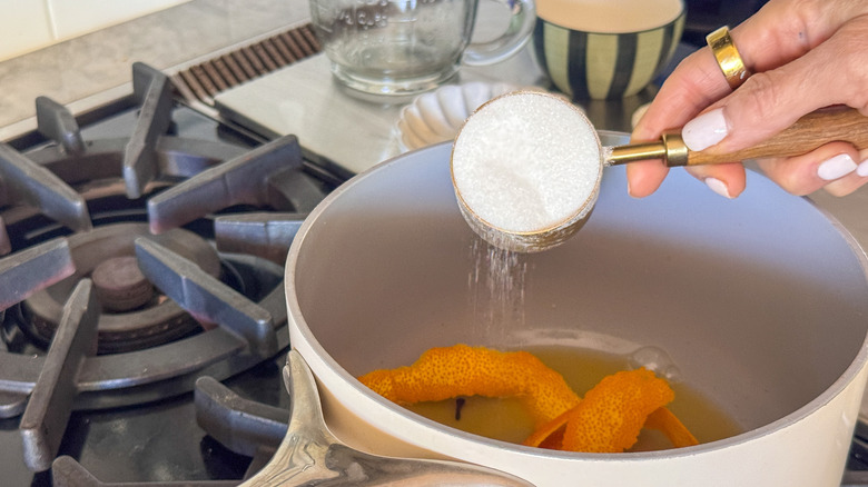 main, ajouter du sucre dans une poêle avec des écorces d'orange
