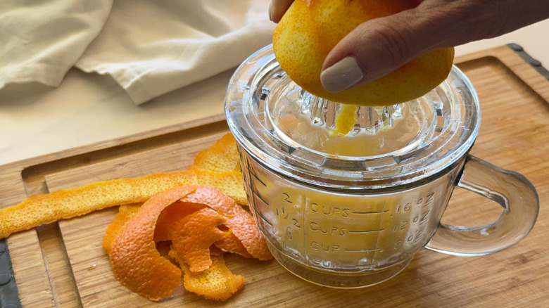 jus d'orange à la main sur un presse-agrumes