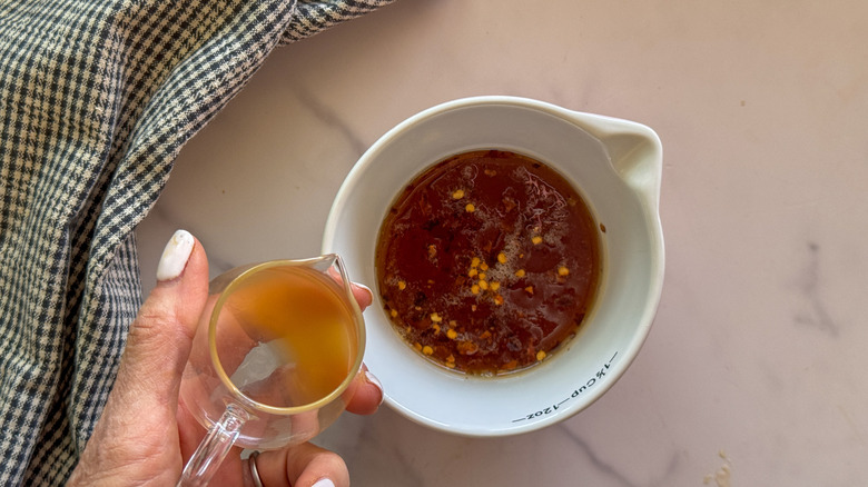 main ajoutant du vinaigre au bol