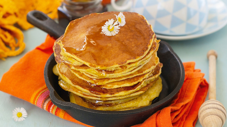 Une pile de johnnycakes arrosés de miel.