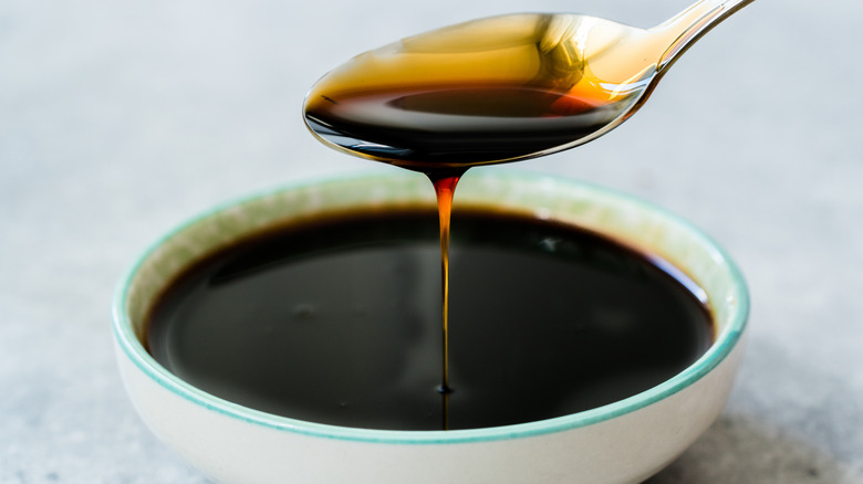 Un petit bol blanc de sirop noir.